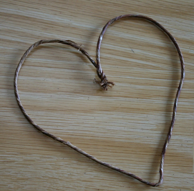 Отрежьте кусок цветочного провода. Согните его в форме сердца. Скрутите концы вместе, чтобы “сердце” держало форму.